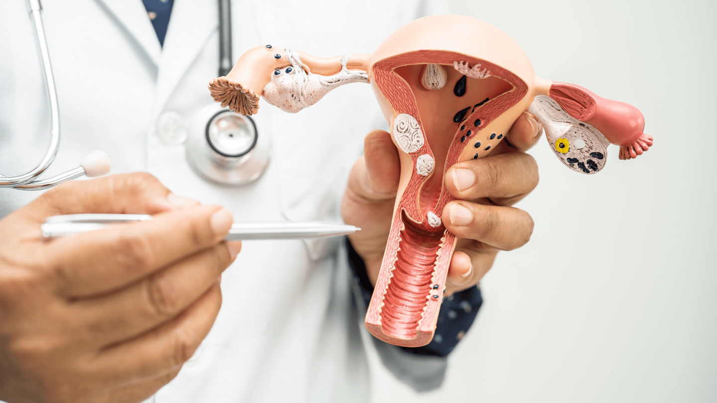 Female doctor in white coat with stethoscope in hospital room